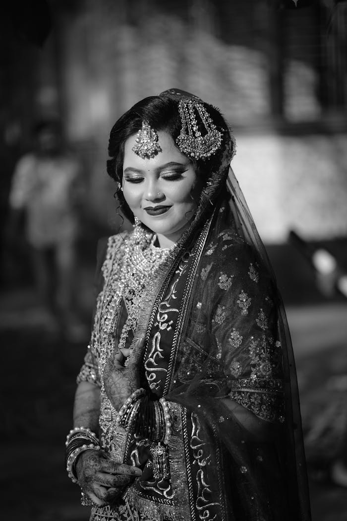 Black and white portrait of a beautifully adorned bride in traditional attire.